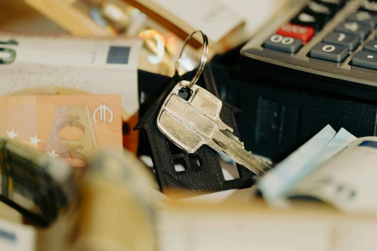 House key and money with calculator representing loan refinancing